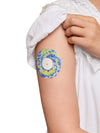 Colorful Freestyle Libre 2 patch with blue and yellow tie-dye design on arm, secure and stylish.