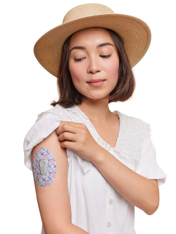 Woman wearing Dexcom G6 sensor patch with spring design on arm.