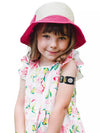 Child wearing Dexcom G7 Armband with rotating clip, playful design, floral dress, and pink hat.