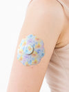 FreeStyle Libre 3 cookie shape patch close-up on arm, showing breathable adhesive support around the sensor