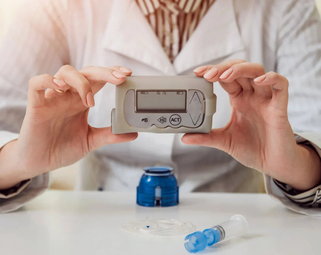 person holding blood glucose meter device with insulin pump components showing diabetes device maintenance and usage