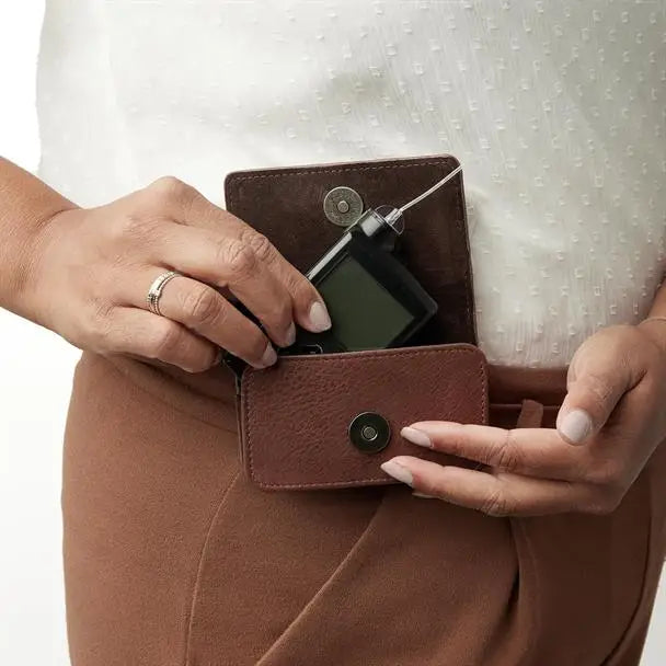 Brown leather insulin pump cases, a protective and stylish accessory for daily use, shown worn on a person's waist. Image
