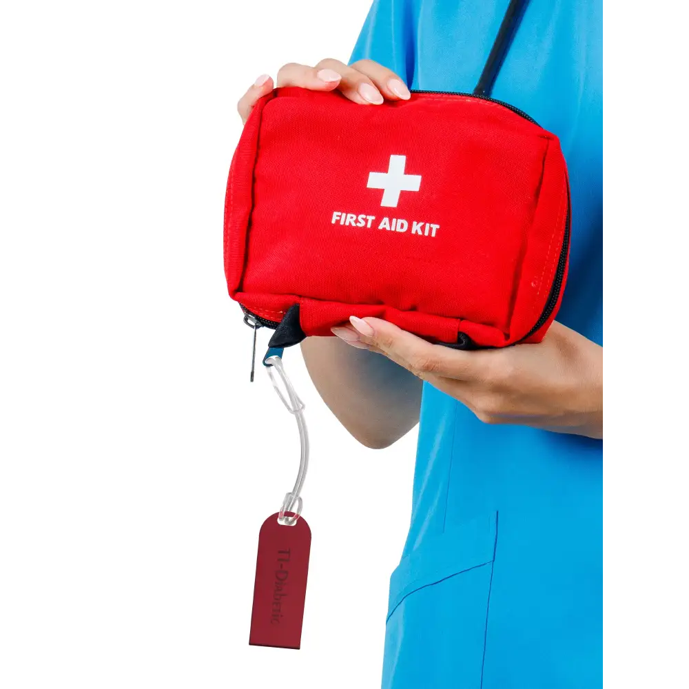 Diabetic luggage tag attached to red first aid kit, highlighting diabetes medical supplies.