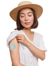 FreeStyle Libre 3 cookie shape patch worn on a woman’s arm, with breathable adhesive fabric for sensor support