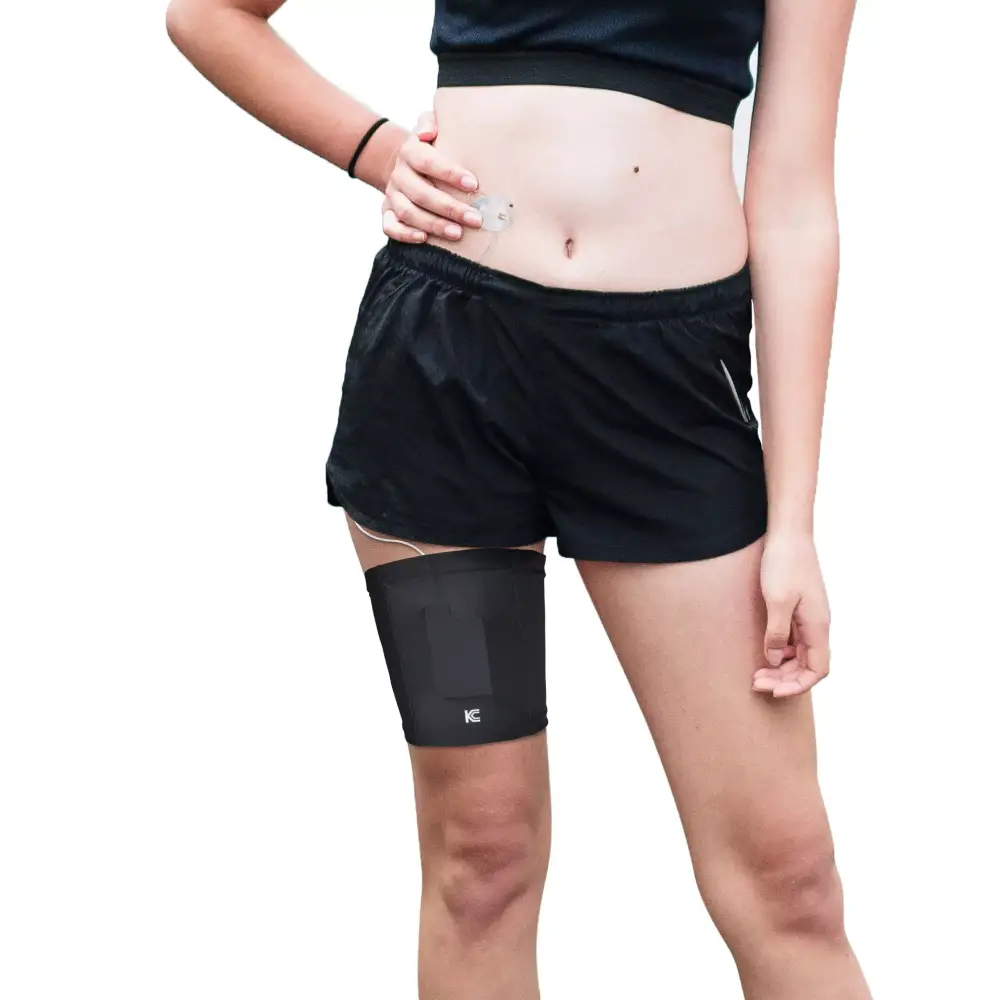 Leg band for insulin pump worn on woman's thigh under shorts, providing convenience and style.